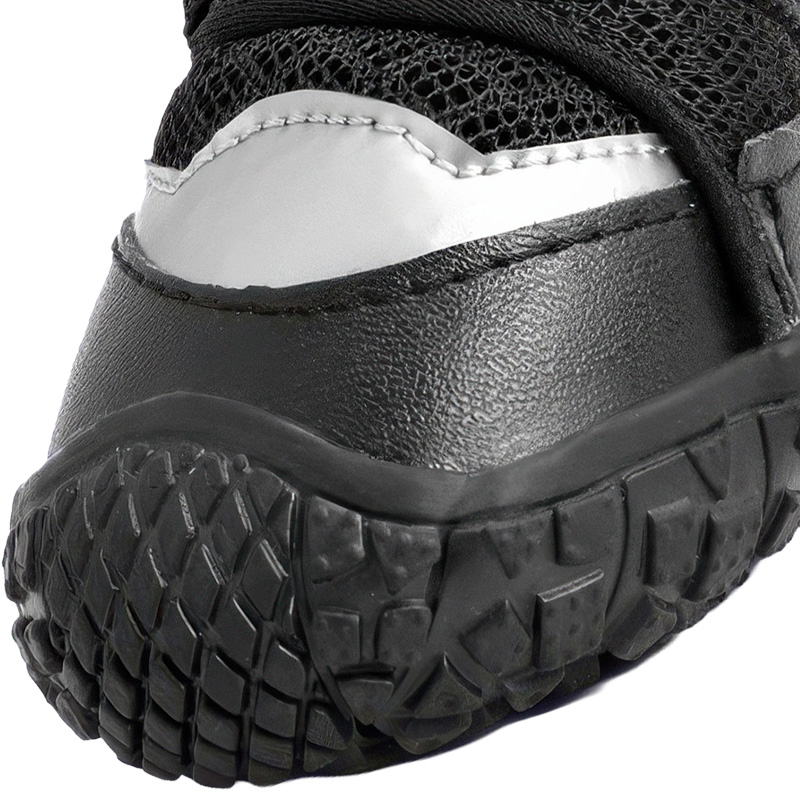 Close profile of a black dog shoe toe cap highlighting a silver reflective patch and tight industrial stitching.