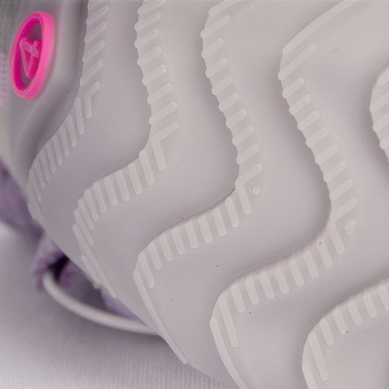 Underneath look at the textured grey rubber base profile on anti-slip snow walking dog shoes showing deep wavy grooves.
