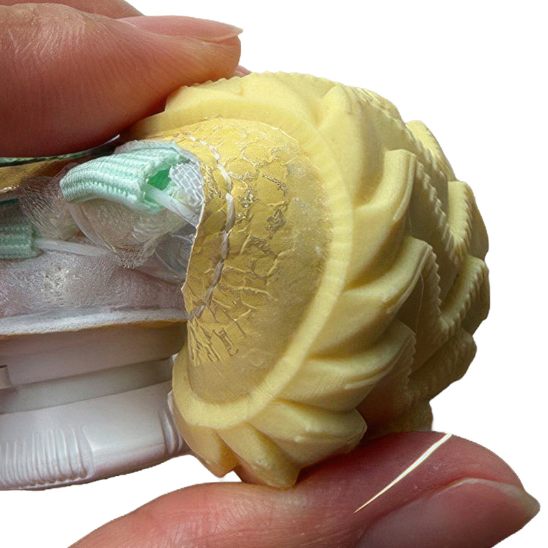 Close view of a hand compressing the soft yellow thermoplastic rubber outsole frame to illustrate organic step flexion.