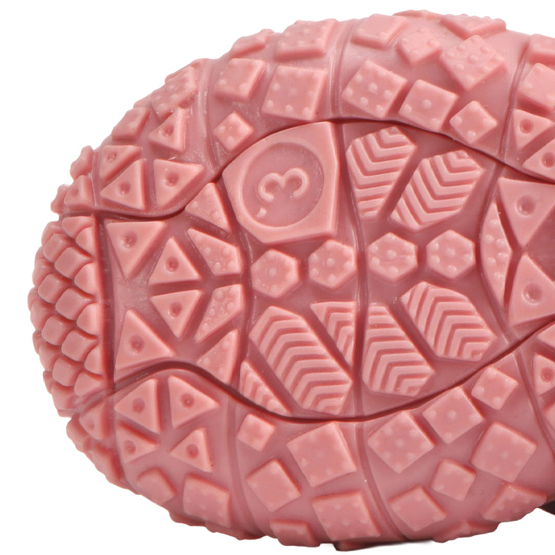 Underneath look at the textured pink rubber outsole on anti-slip TPR sole paw protectors showing geometric traction lines.