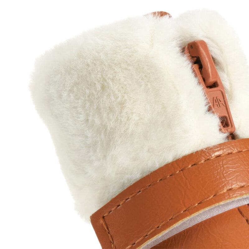 Macro view focusing on the fluffy white rabbit fur trim collar and brown zipper puller of cute faux fur warm dog shoes.