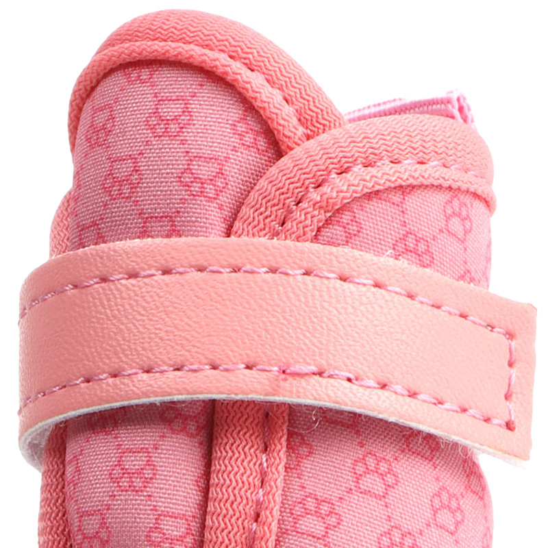 Macro view focusing on the pink printed stretch fabric upper and soft velvet collar piping on water resistant small dog shoes.