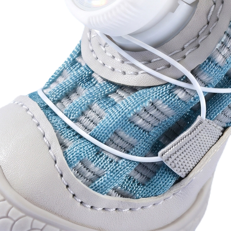 Macro view focusing on the specialized wire lace routing across the open-mesh fabric and grey leather mudguard panels.