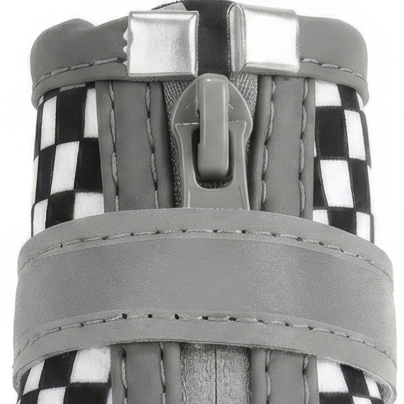 Close-up macro view of the heavy-duty front zipper slider and wide grey reflective wrap strap on checkered dog boots.