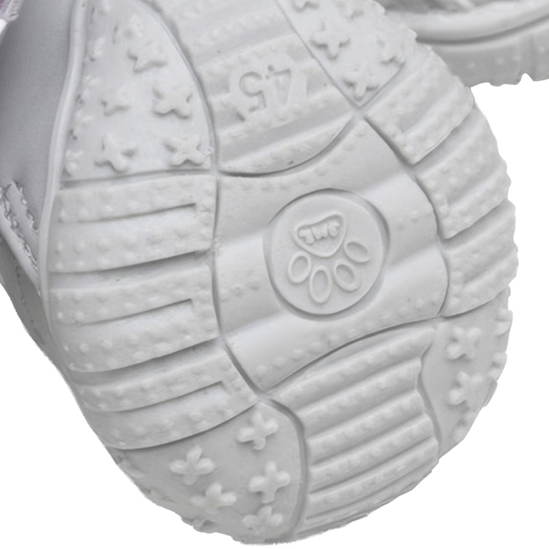 Underneath macro view of the thick gray flexible rubber outsole highlighting star pattern traction geometric grooves.