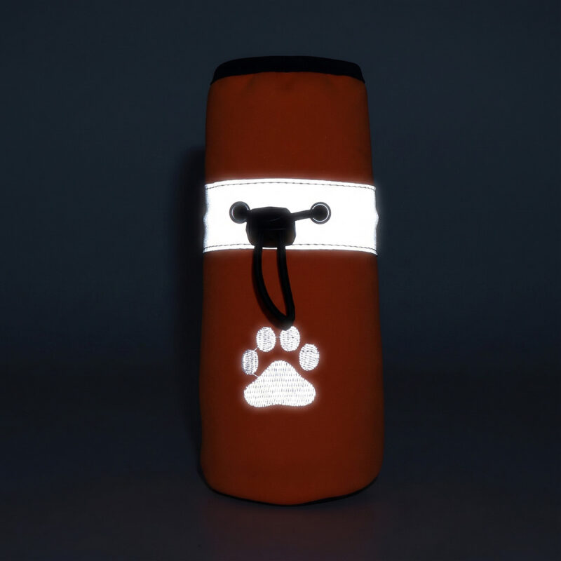 Close-up front view of a black reflective fleece lined dog shoe showing the ankle collar band glowing intensely in the dark.