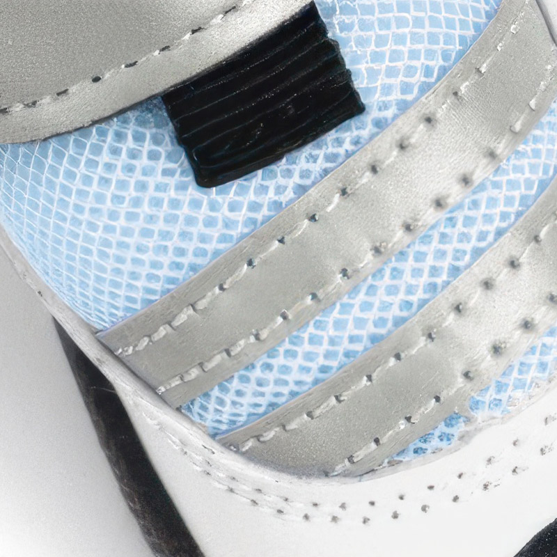Detailed macro view of the double-stitched air-layer mesh fabric and silver reflective panels on blue dog shoes.