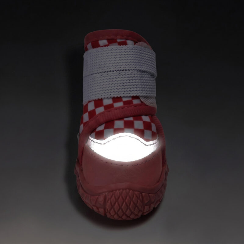 High Visibility Night Safety Reflective Toe Glow Front view of a red checker reflective waterproof dog shoe with its silver crescent toe patch glowing under low light.