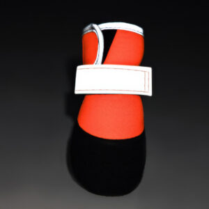 Silver reflective trim glowing on orange waterproof neoprene dog shoes for safe nighttime outdoor walking.