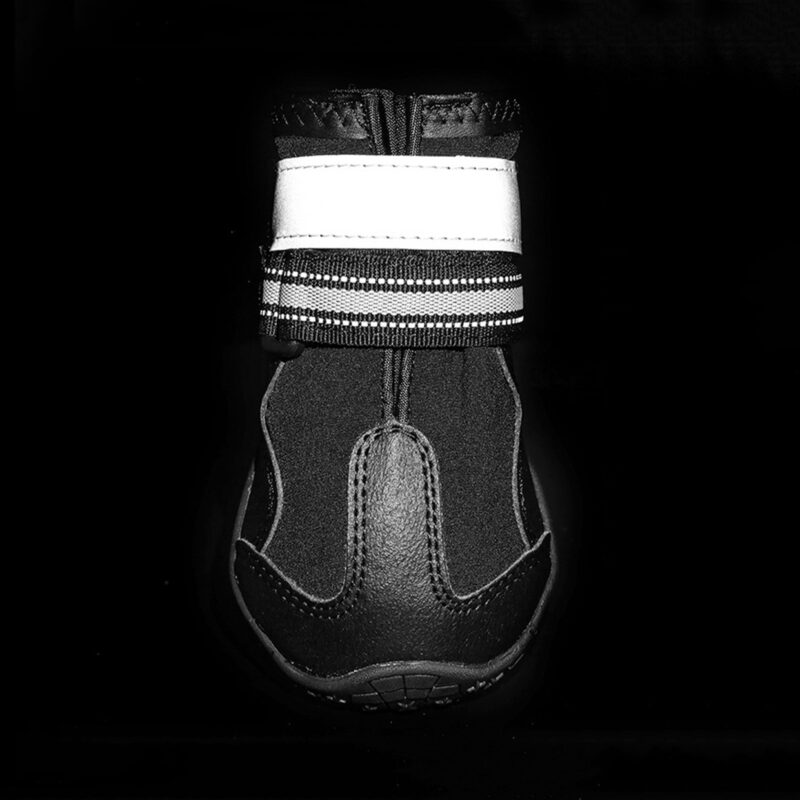 High-Visibility Night Safety Reflective Strap Close-up of black reflective waterproof pet shoes highlighting the 3M ankle strip glowing intensely under dark conditions.
