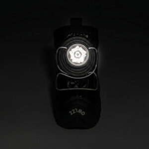 High Visibility Safety Reflective Dial Glow Front view of a black reflective winter dog shoe with its circular mechanical dial face glowing brightly in pitch darkness.