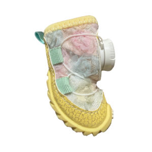 Side look at a yellow pastel stay-on dial-system puppy shoe highlighting pink and blue fabric gradient tones.
