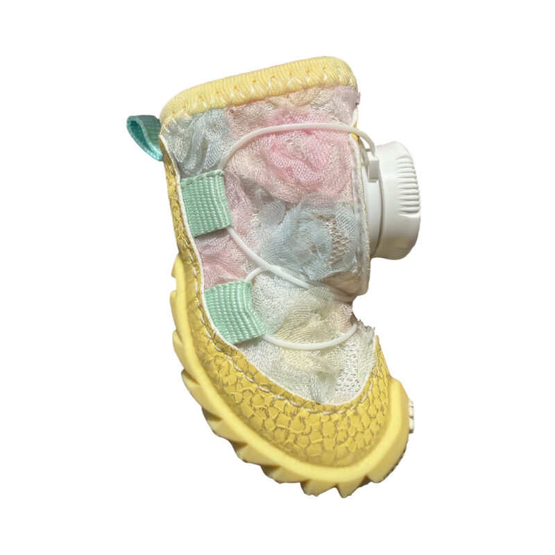 Side look at a yellow pastel stay-on dial-system puppy shoe highlighting pink and blue fabric gradient tones.
