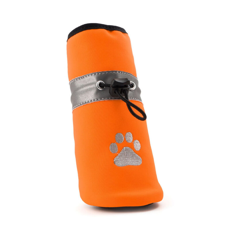 Three-quarter view of orange stay-on winter shoes for small dogs emphasizing the single-pull elastic cord adjustment mechanism.