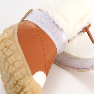 Close profile of a mocha brown stay-on zipper puppy shoe with its horizontal micro adjustable hook and loop strap extended wide.