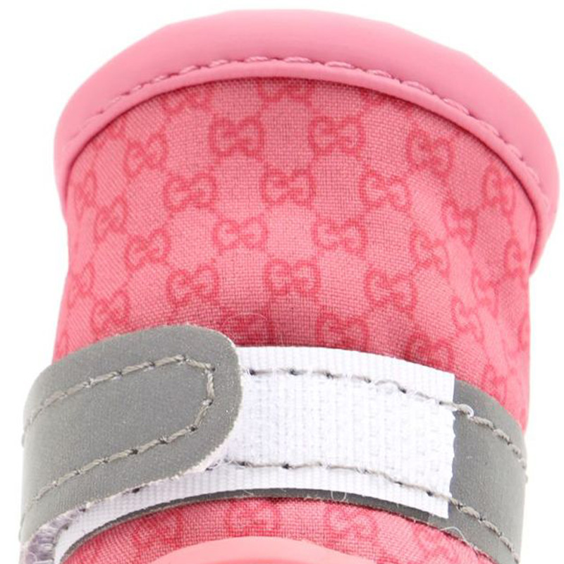 Macro view of a blush pink printed fabric upper highlighting close double stitching and a grey reflective safety strap.