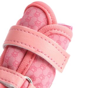 Macro view focusing on the pink leather mudguard wrap and close interlocking needle stitching lines on small dog shoes.