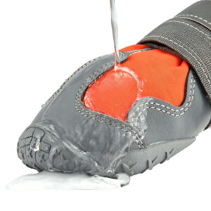 Four-Way Stretch Hydrophobic Fabric Shell Test Water pouring directly over orange waterproof high-top dog shoes to show the hydrophobic performance textile.