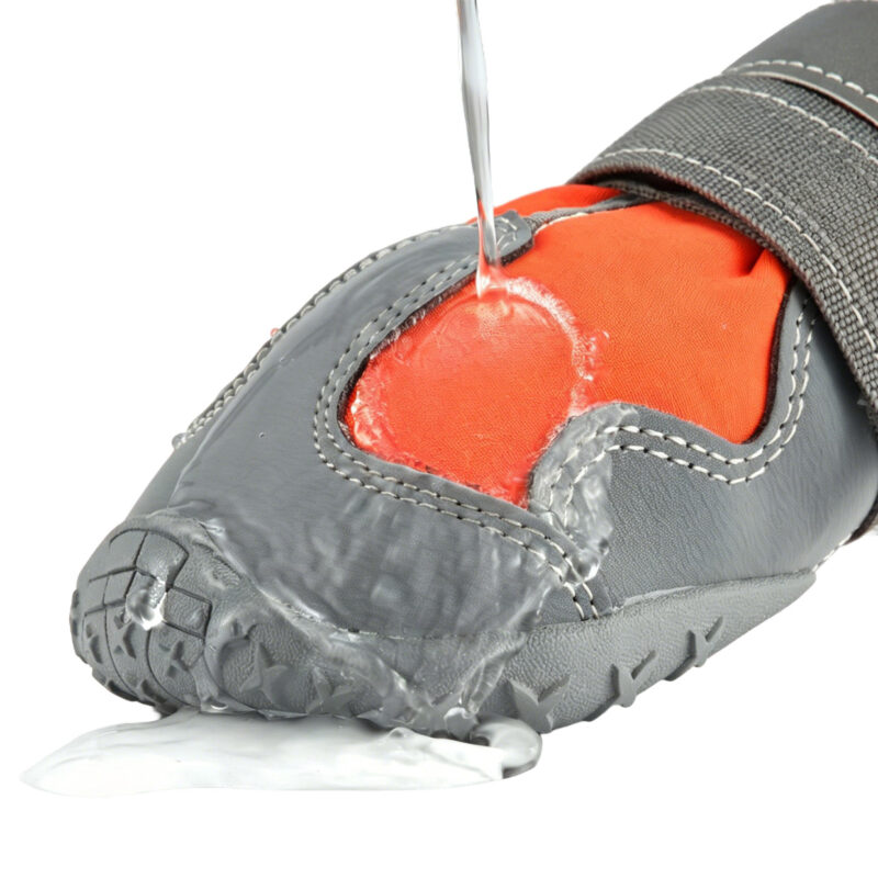 Four-Way Stretch Hydrophobic Fabric Shell Test Water pouring directly over orange waterproof high-top dog shoes to show the hydrophobic performance textile.