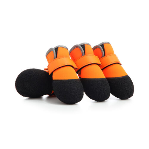 Four orange waterproof neoprene dog shoes with textured black non slip latex soles shown on a white backdrop.