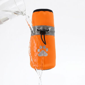 Water pouring directly over an orange winter water-resistant fleece dog shoe to demonstrate excellent water resistance beading.