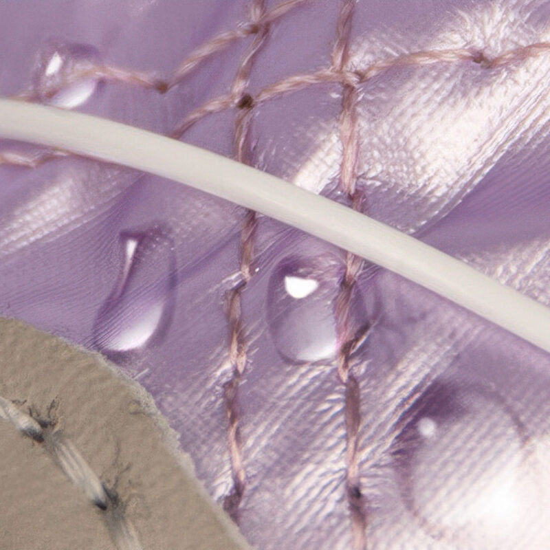 Hydrophobic Quilted Oxford Cloth Performance Detail Close up look at direct water droplets beading off the quilted waterproof Oxford fabric shell of taro purple shoes.