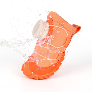 Water splashing over the hydrophobic outer canvas shell of an orange all-weather waterproof dog shoe during a barrier test.