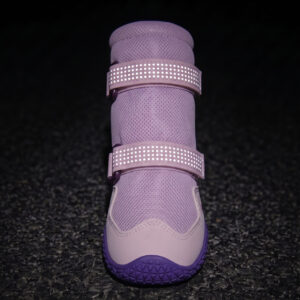 Dual retroreflective straps glowing bright on breathable protective dog boots under dark environment conditions.