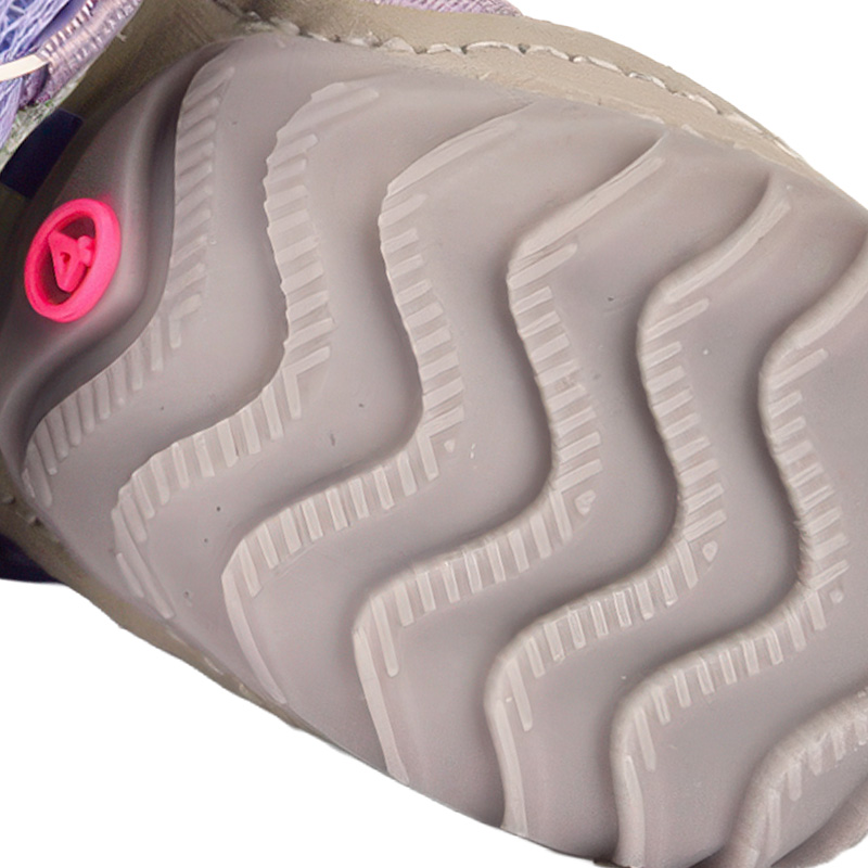 Underneath look at the textured gray rubber base on comfort fit soft-sole dog shoes showing progressive wave grooves.