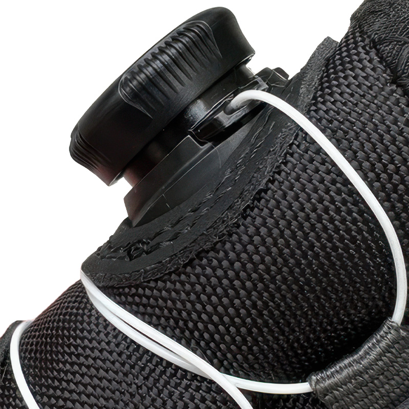 Close up look at the black circular mechanical wire tension dial and wire routing track guides on a winter bootie.