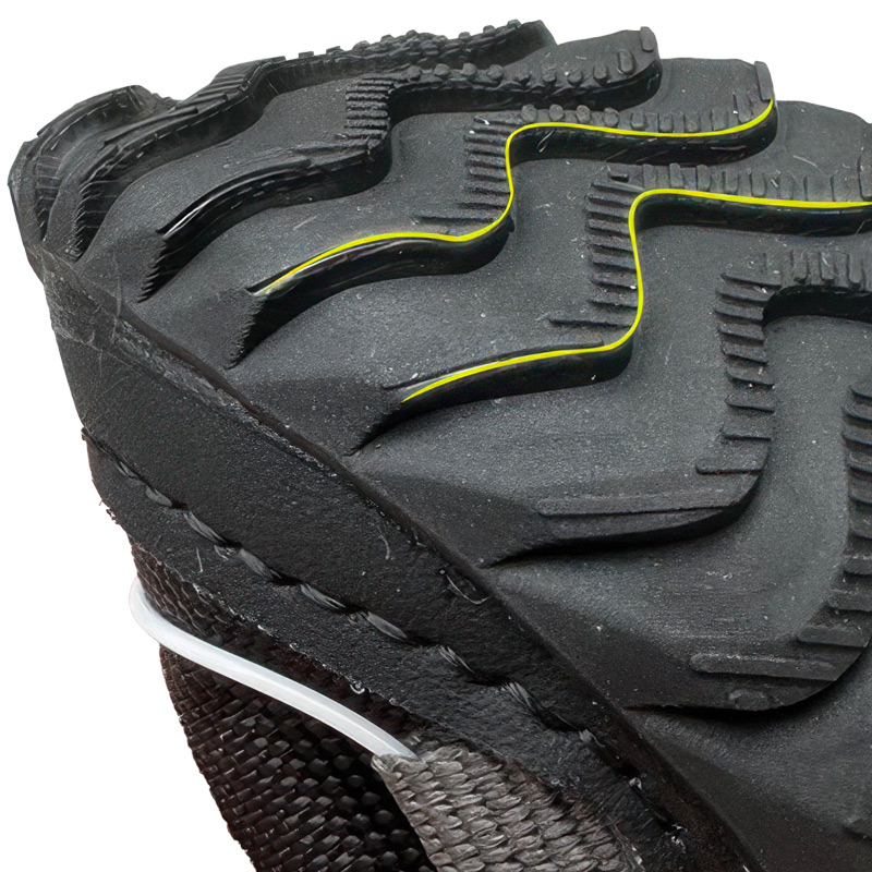Underneath look at a black flexible rubber outsole showing deep contoured wave traction grooves with yellow trace highlights.