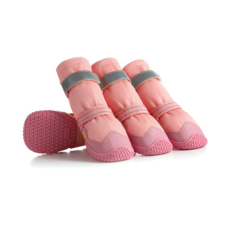 A set of four blush pink high-top dog boots with anti-slip rubber soles and reflective straps, showing both the textured tread and side profile on a white background.
