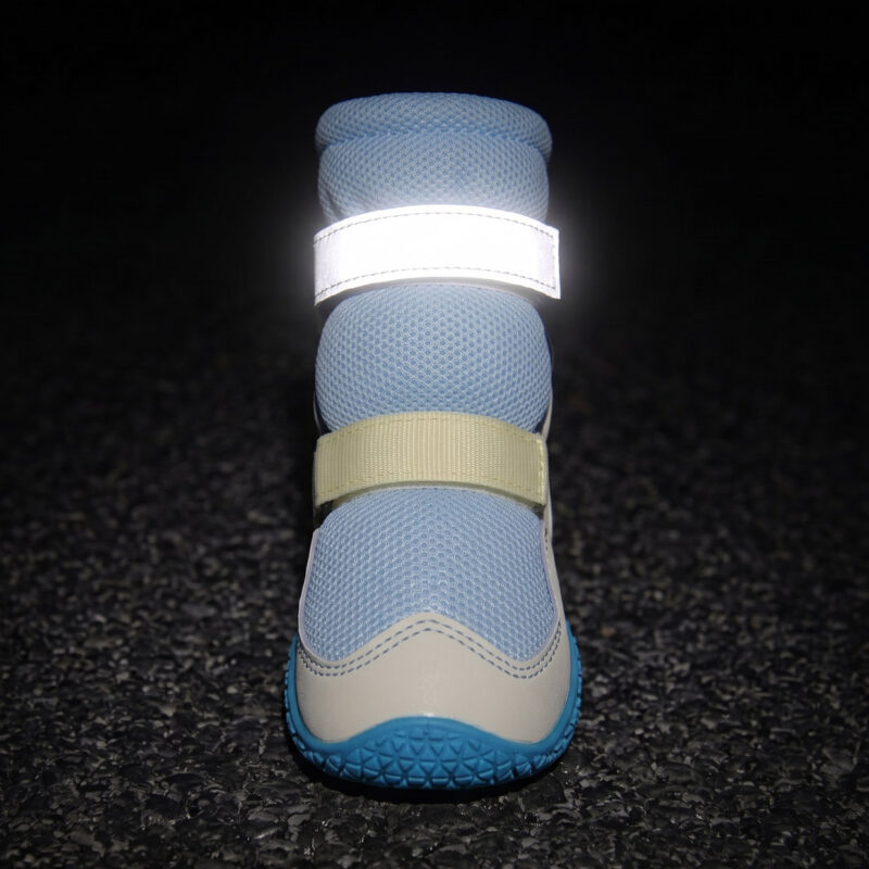 High-top dog boots for large dogs showing the bright retroreflective top strap glowing under night conditions.
