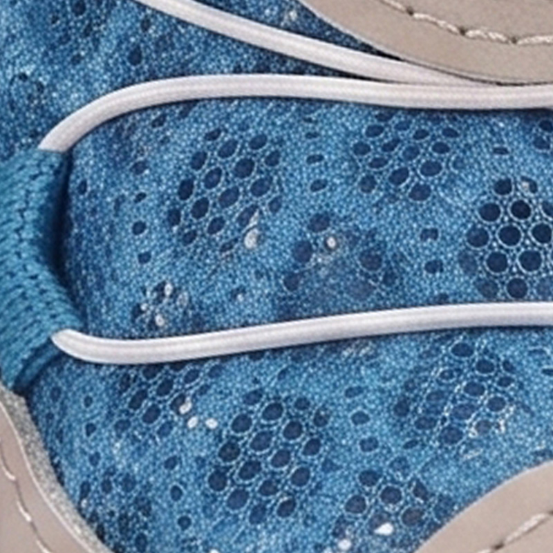Close macro look at the porous blue open hole honeycomb ventilation canvas mesh upper and wire lace routing.