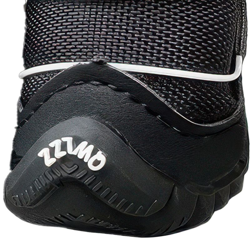 Front profile detail of a black winter dog shoe showing a textured rubber mudguard wall and stitched toe cap bumper.