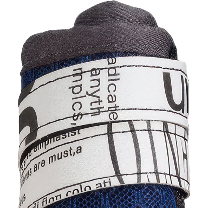 Macro close up view of large breed dog shoes showcasing the extended newspaper print microfiber velcro strap.