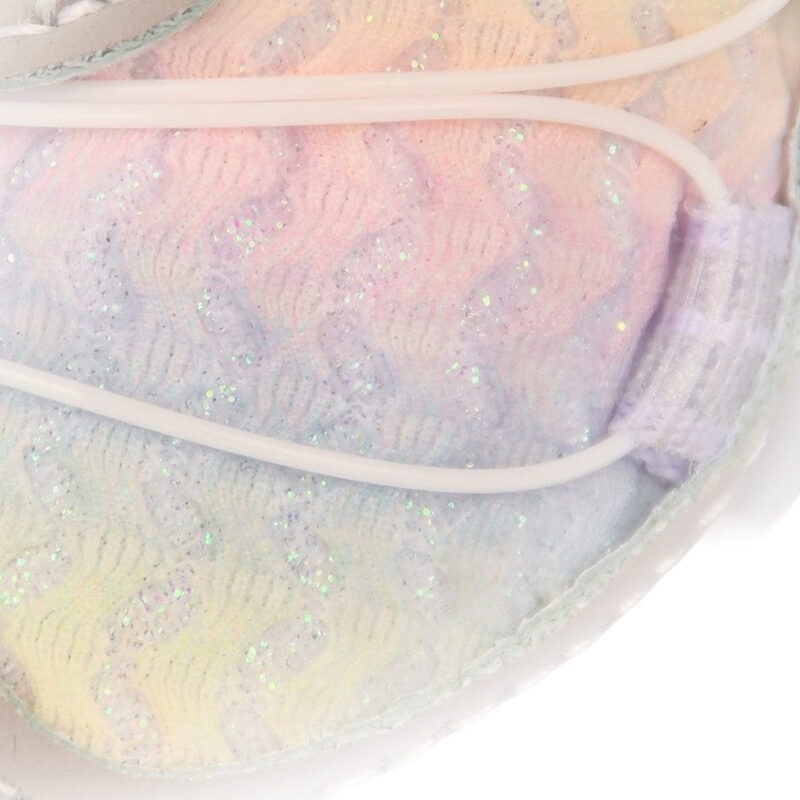 Macro view focusing on the glitter-infused rainbow pastel canvas and white tension wire of protective dog shoes.