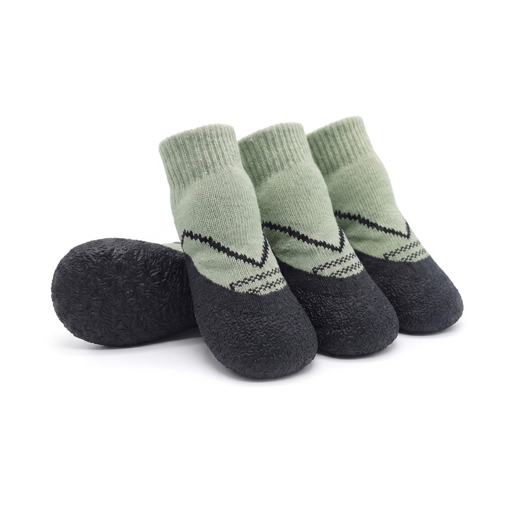 Sage green paw protection dog socks showing black chevron accent lines and a thick textured rubber base.