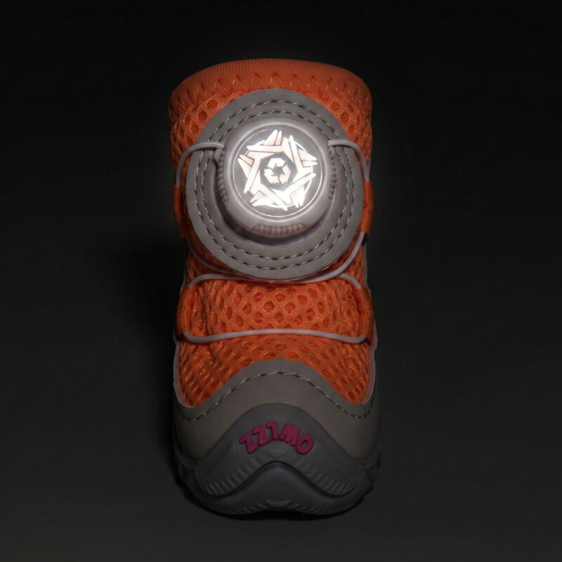 High Visibility Night Safety Reflective Dial Glow Front view of an orange reflective safety walking dog shoe with its central circular wire dial glowing under darkness.