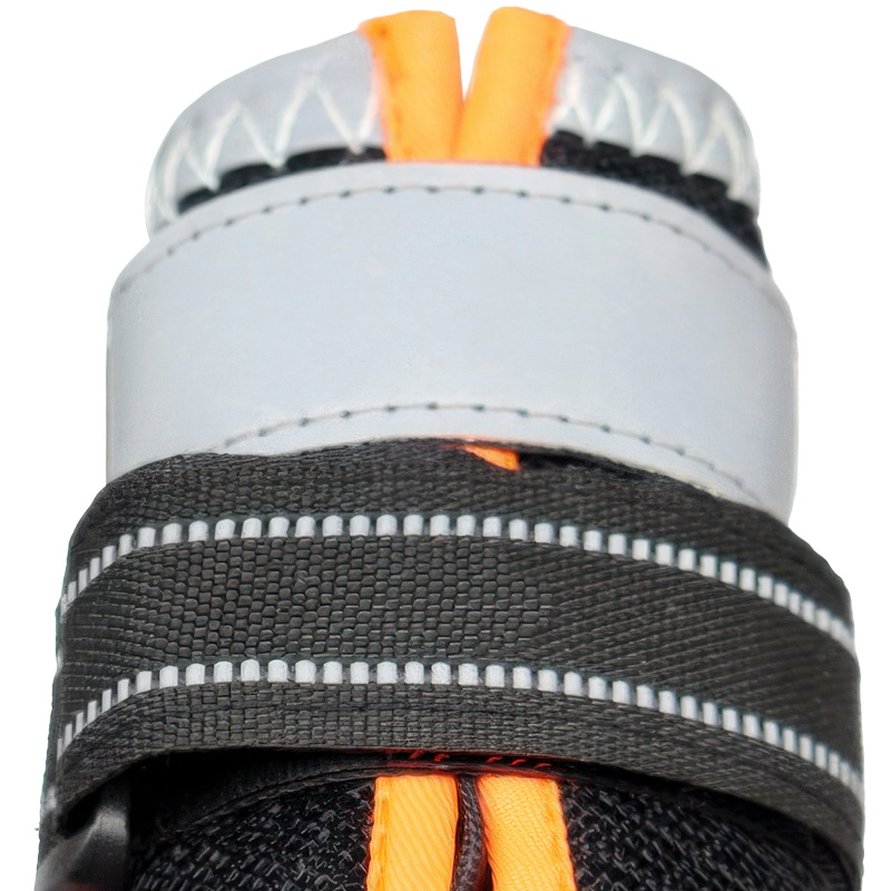 Macro close up of reflective walking shoes for dogs showing the industrial grey stitching and wide silver luminous collar.