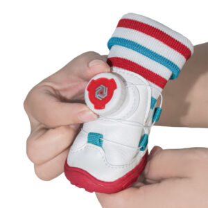 Step By Step Clockwise Dial Tension Locking Demonstration Close up of hands turning the mechanical red dial on sock-top dog shoes to demonstrate clockwise tension locking.