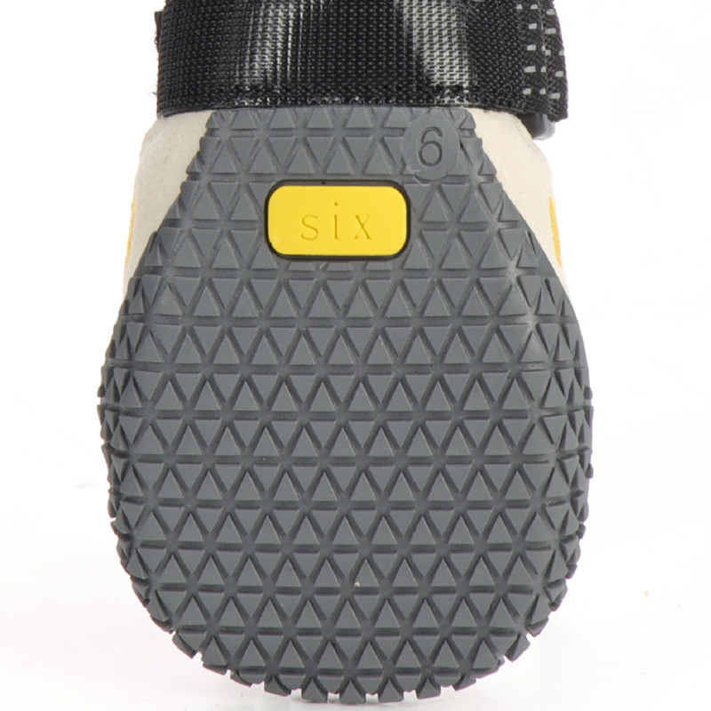Heavy-duty rubber tread on soft-sole dog boots for walking displaying a secure anti-slip traction matrix.