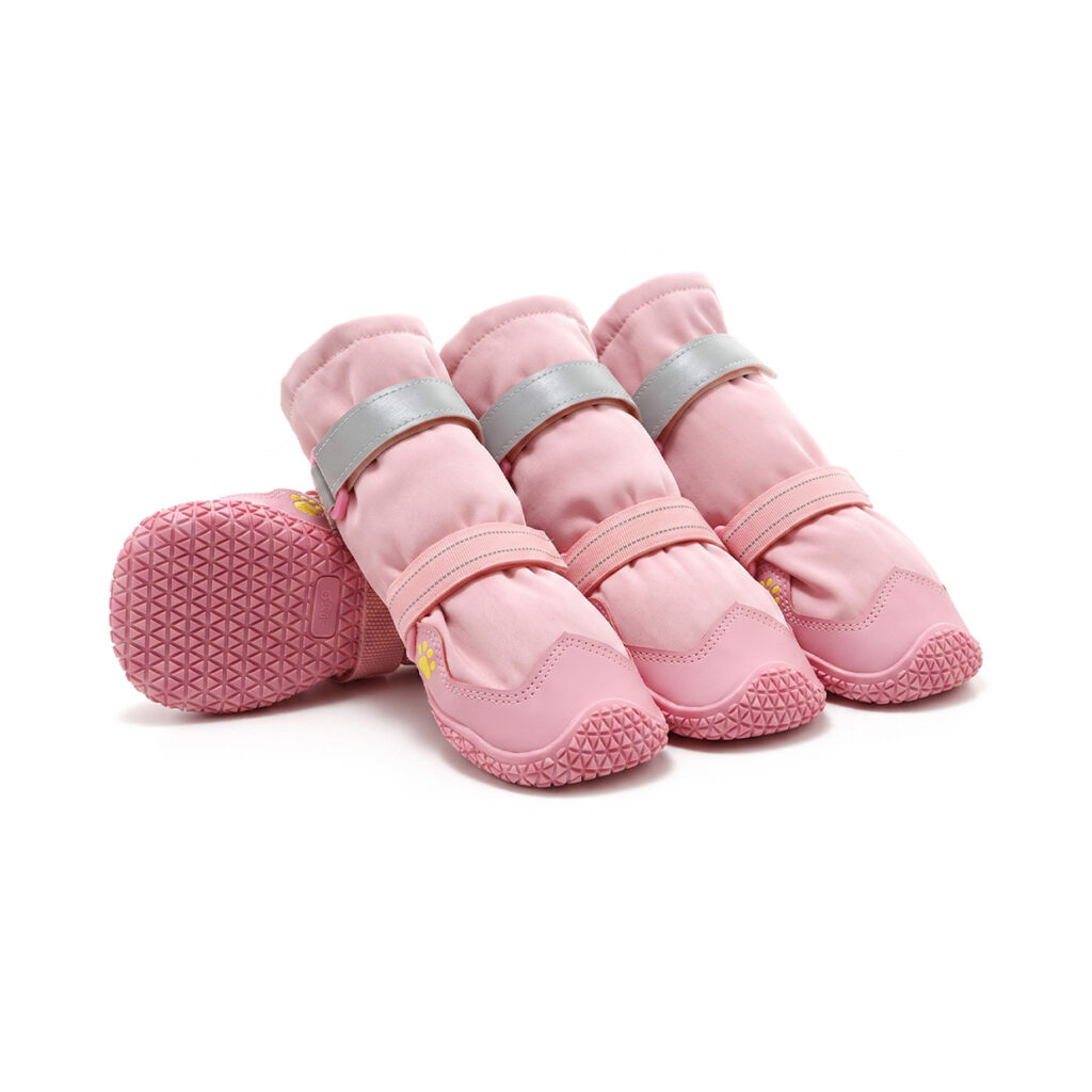 Stretch fabric dog boots in blush pink showing four structured tall-shaft booties with pink anti-slip rubber soles.