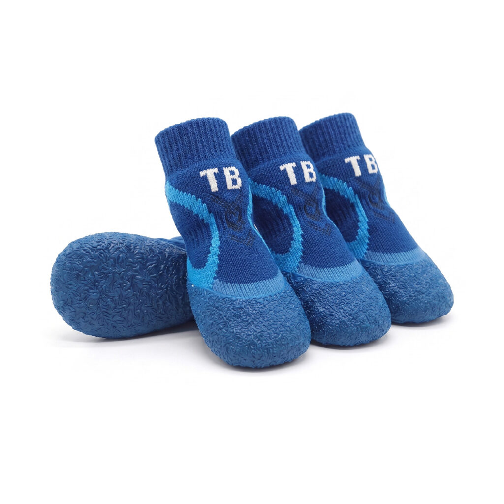 Royal blue winter warm dog socks with printed white athletic lettering and a durable textured blue rubber base.